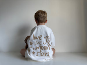 Child wearing a white shirt with 'I love you to the moon and stars' text.